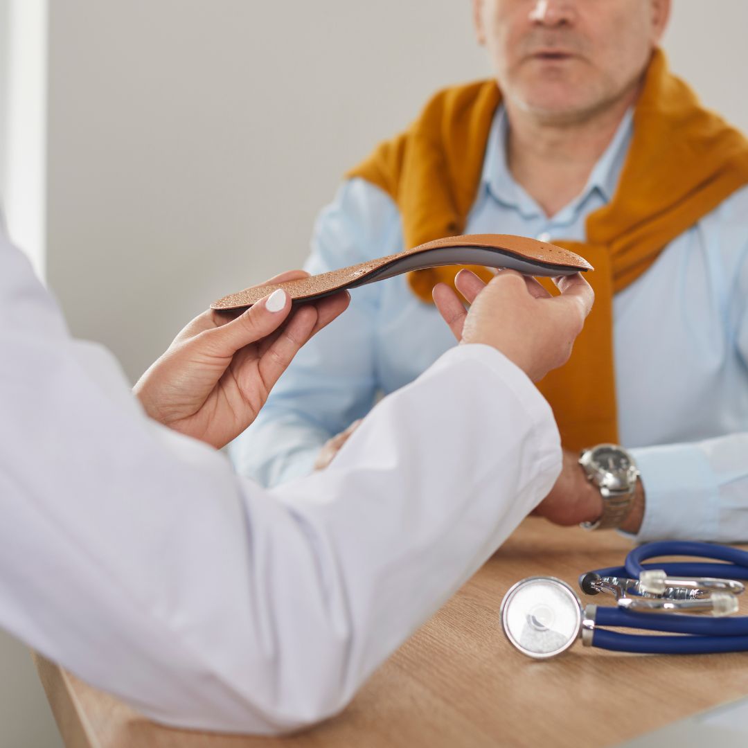 Doctor showing patient a shoe insert